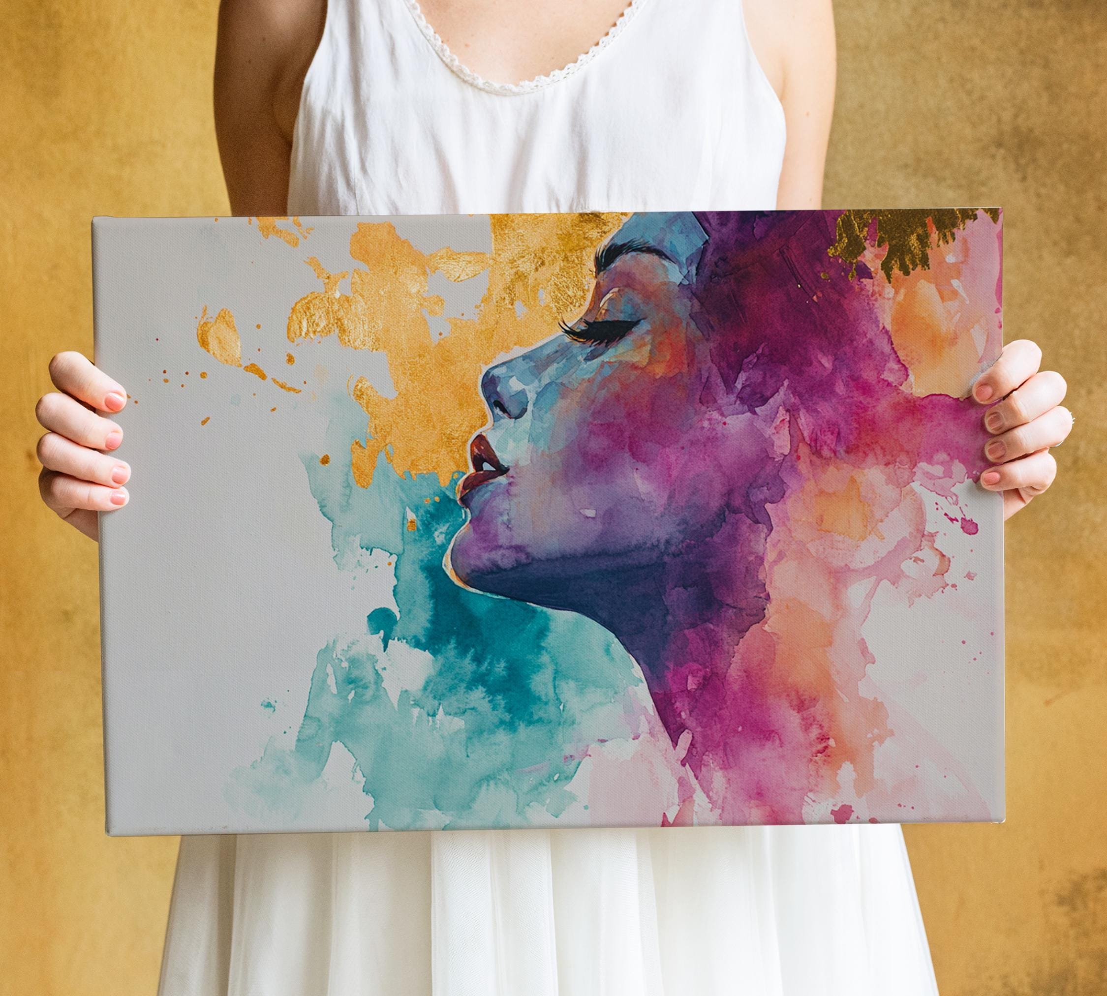 A woman is holding a large canvas print featuring a colorful, abstract portrait of a woman's face.
