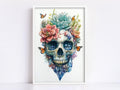 a skull with a floral arrangement on top of it, including a pink flower, a blue flower, and butterflies.