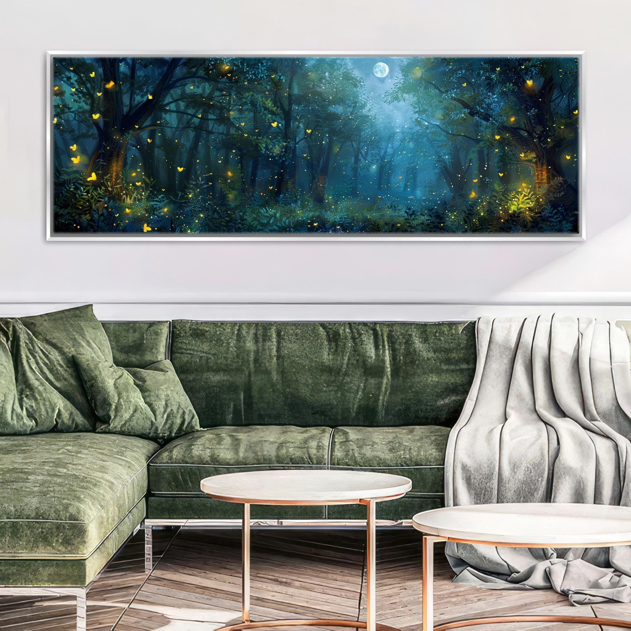 a large, framed painting of a forest scene with a full moon and glowing fireflies, hanging on a wall above a green sofa and two round coffee tables.