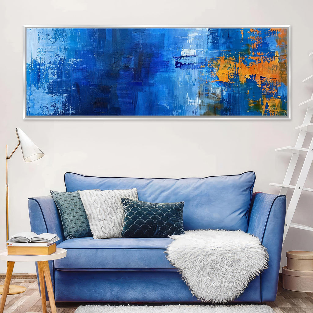 a living room with a blue couch and a painting on the wall