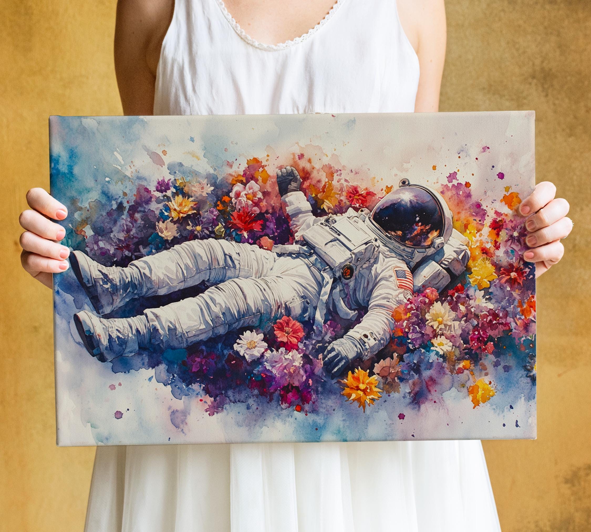 A person is holding a canvas print featuring an astronaut floating in a colorful flower field.