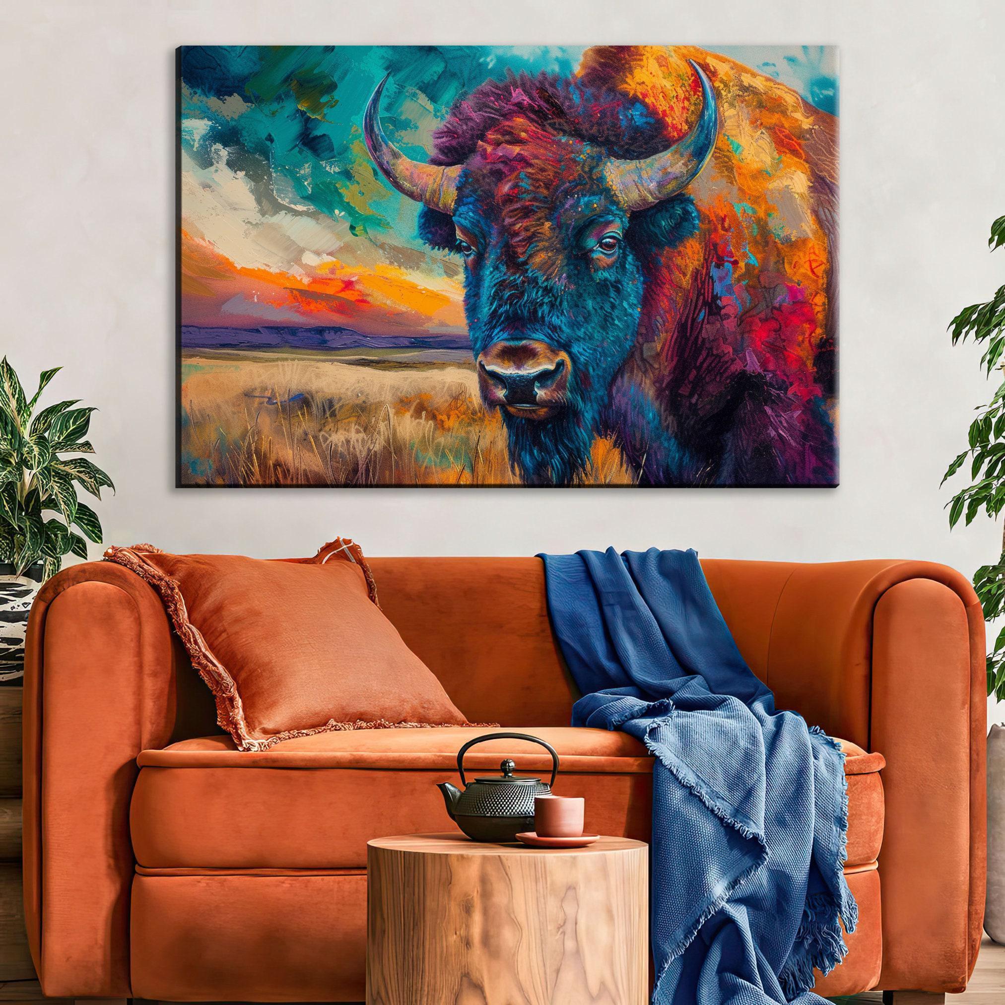 a large, colorful painting of a buffalo on the wall above a cozy living room setting with a brown sofa, a wooden side table, and a potted plant.
