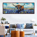 a large painting of a bull with horns, set against a backdrop of a field with blue flowers, hanging on a wall above a couch and coffee table in a living room.