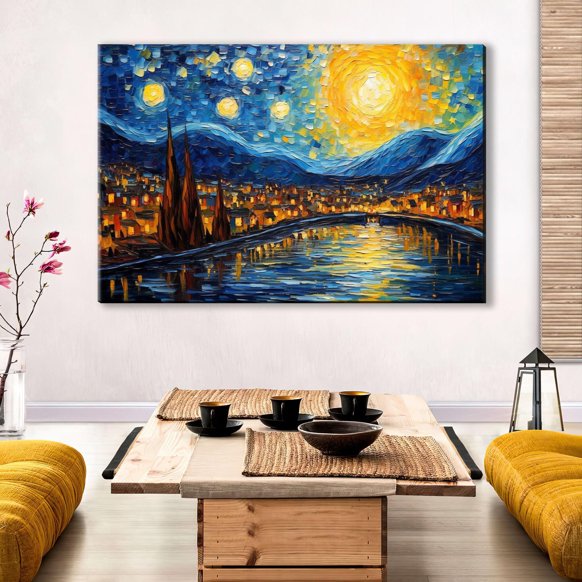a large, vibrant painting of a cityscape with a starry night sky above, depicting a river and mountains in the background. The painting is hung on a wall above a wooden coffee table with a bowl and cups on it. The room has a cozy, inviting atmosphere with yellow couches and a vase of flowers, creating a warm and welcoming environment.