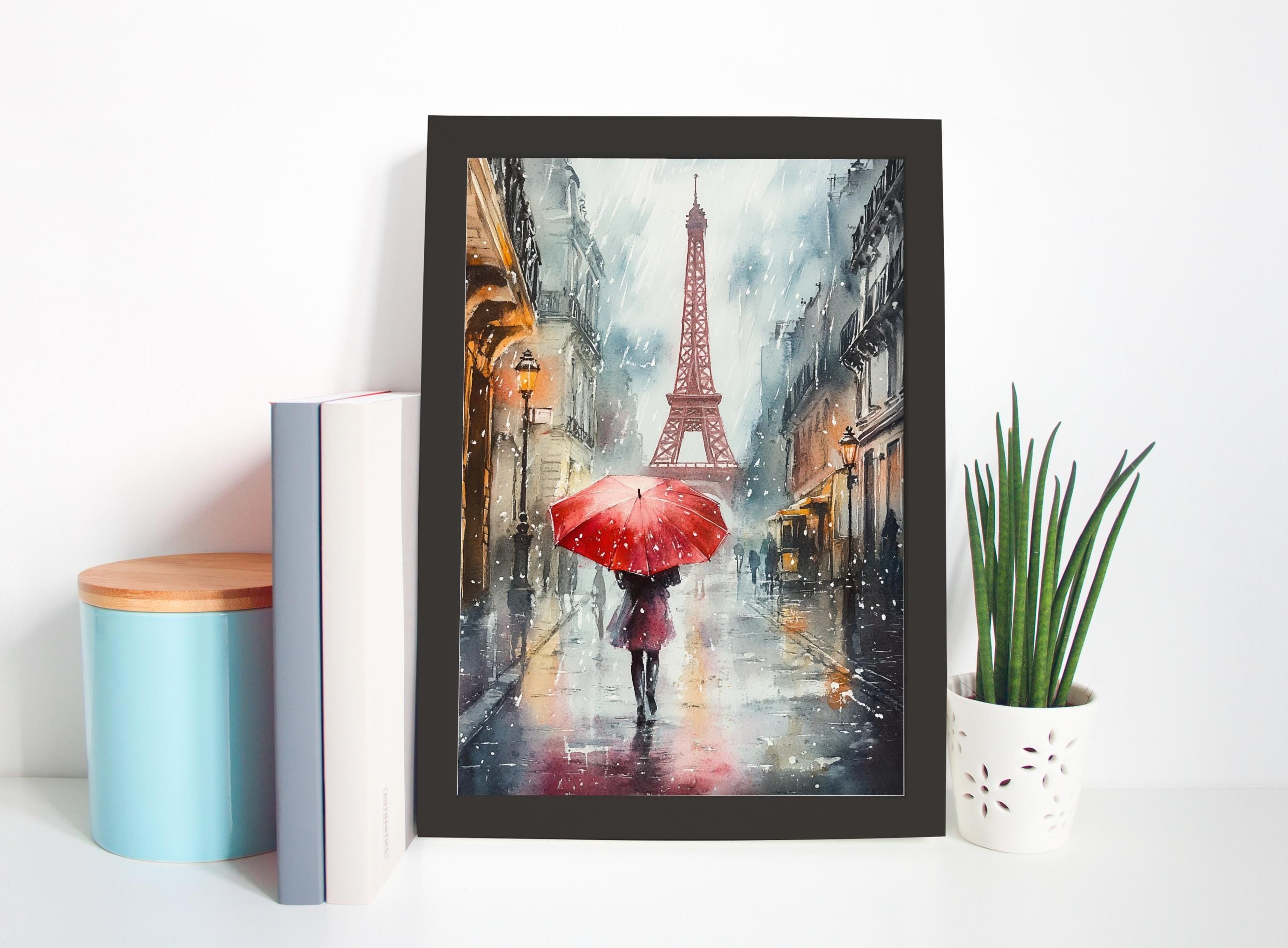 a framed painting of a woman walking with a red umbrella in front of the Eiffel Tower on a rainy day in Paris.