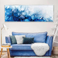 a living room with a blue couch and a painting on the wall