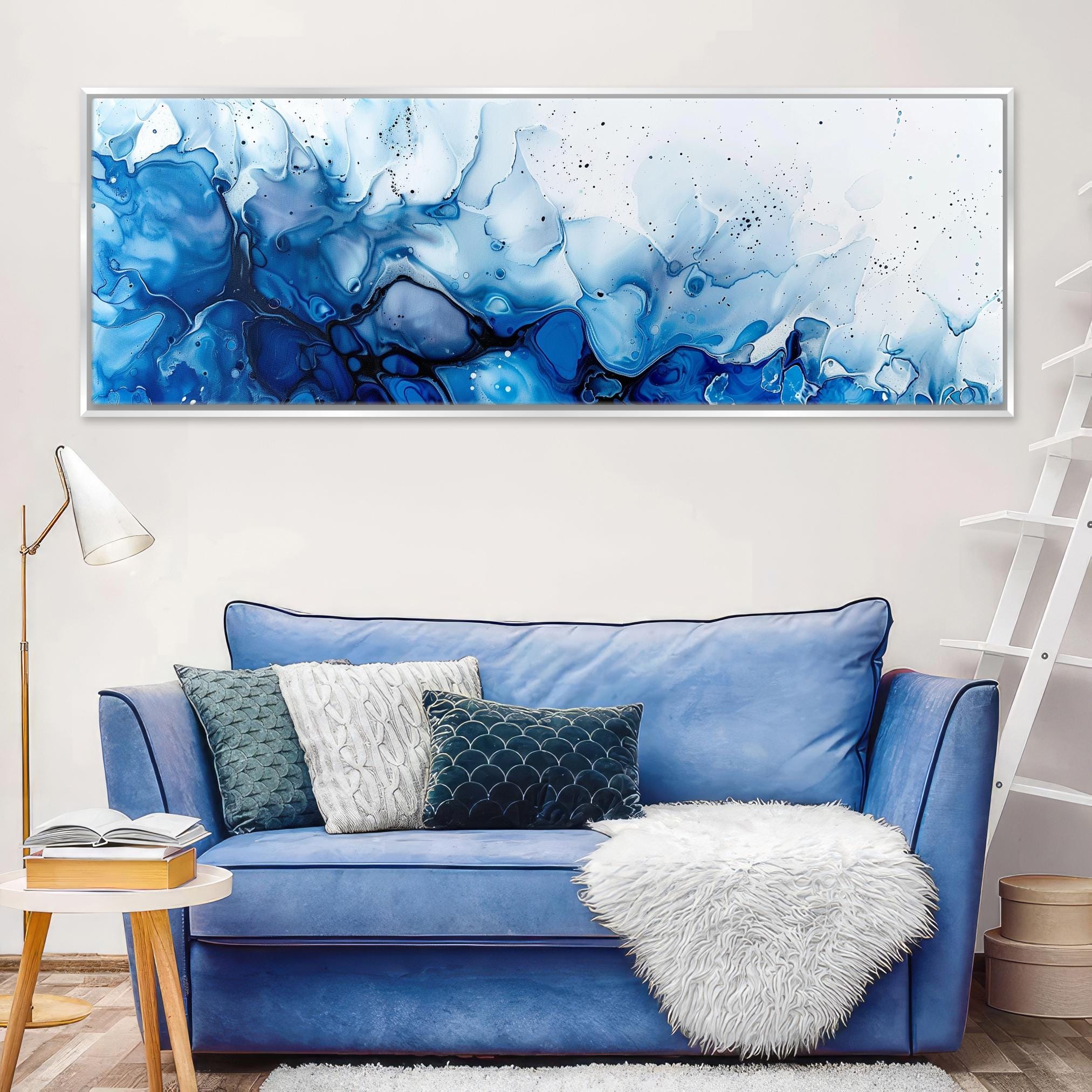 a living room with a blue couch and a painting on the wall