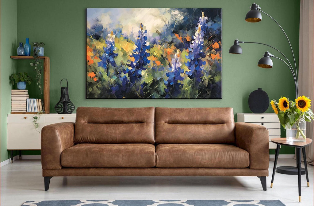 a large, colorful painting of flowers hanging on a green wall above a brown leather sofa in a cozy living room setting.