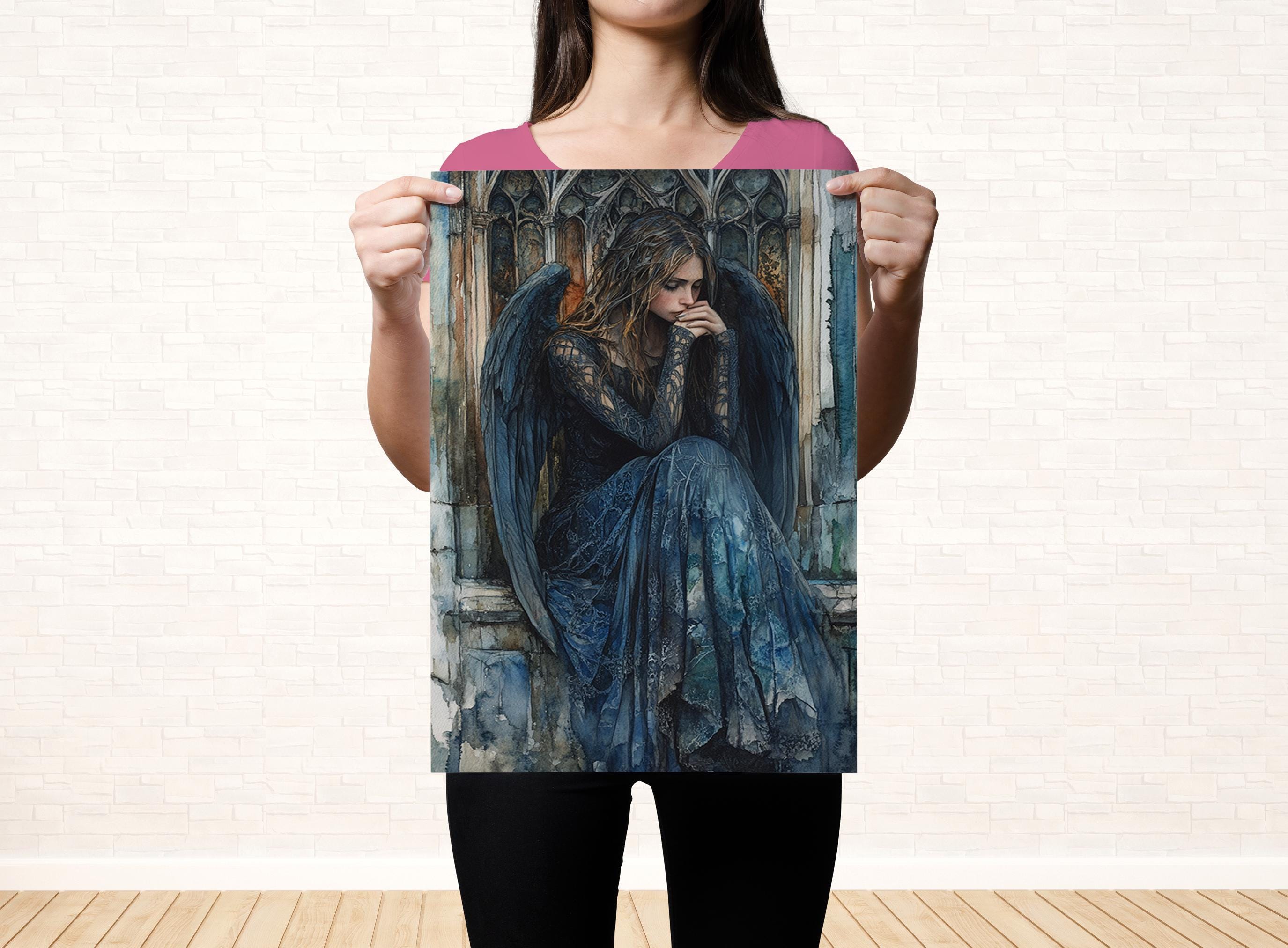 A woman is holding up a framed print of a painting depicting a woman with wings, wearing a long blue dress.