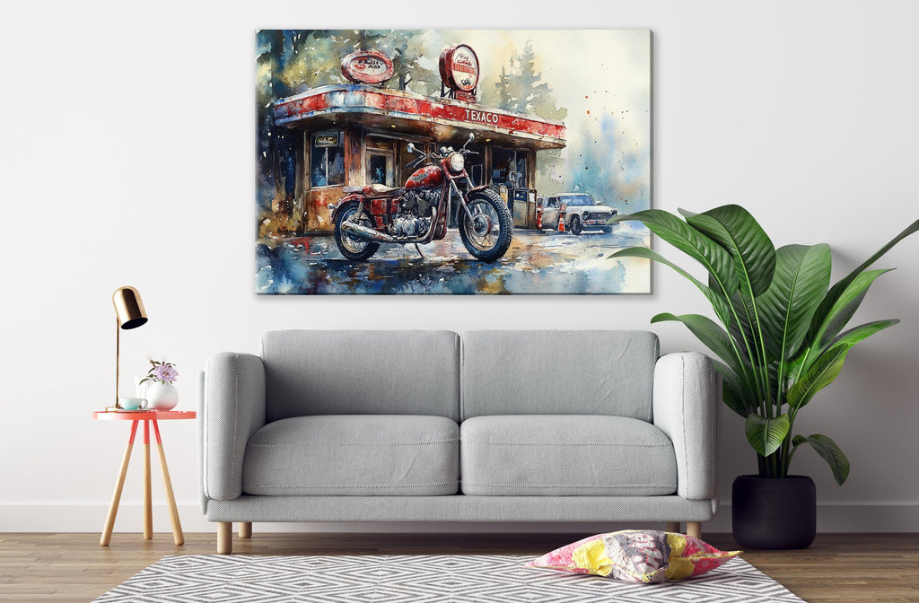 a gray sofa, a potted plant, and a painting of a motorcycle and a gas station on the wall above it.