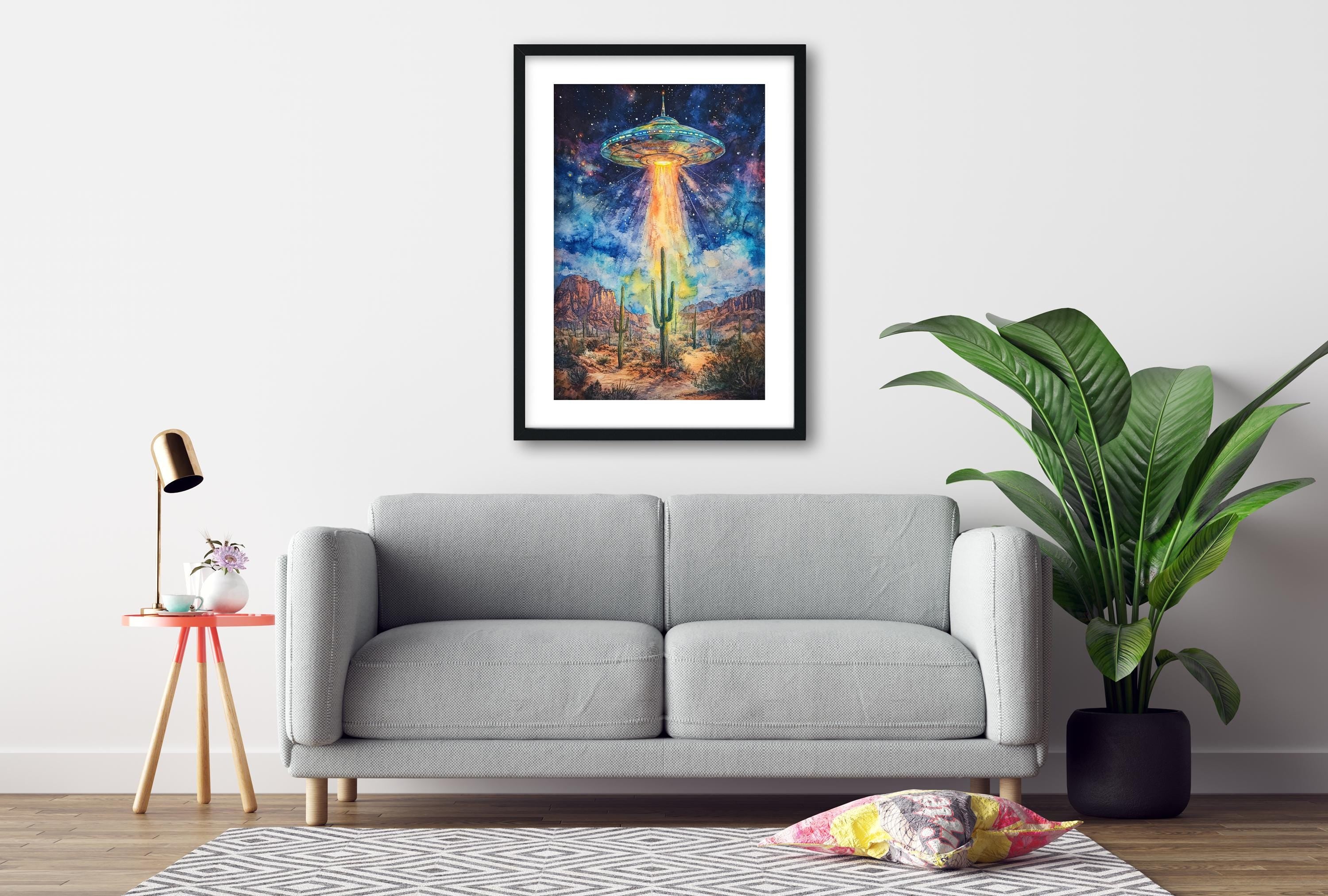 a gray sofa, a framed artwork of a colorful alien spacecraft, a small table with a lamp, and a potted plant, all arranged in a cozy living room setting.