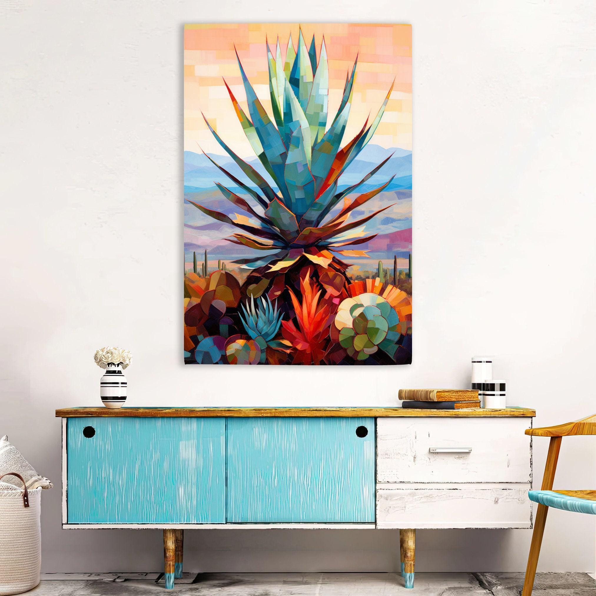 a vibrant, colorful painting of a cactus plant hanging on a wall above a blue cabinet with a wooden top.