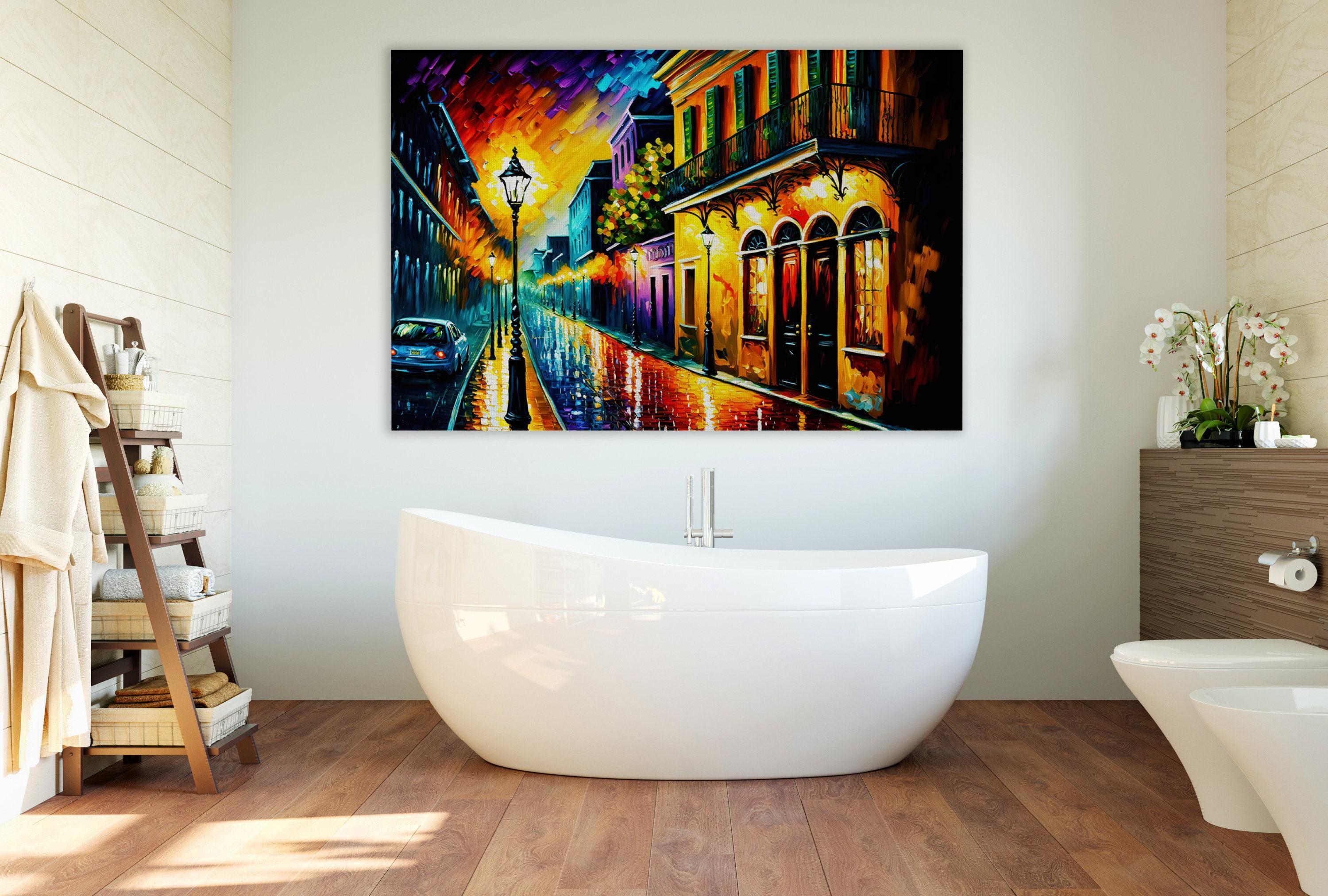 a bathroom with a large, colorful painting of a city street hanging on the wall above a white freestanding bathtub.