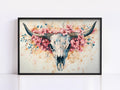A framed painting depicting a skull surrounded by pink flowers and branches.