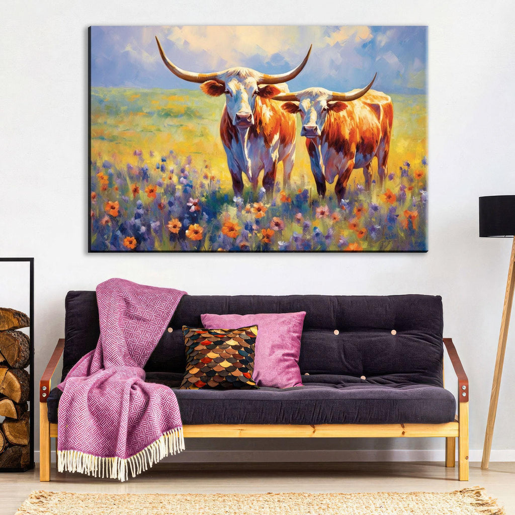 a large painting of two longhorn cattle standing in a field of flowers, with a purple blanket and throw pillow on a couch in the foreground.