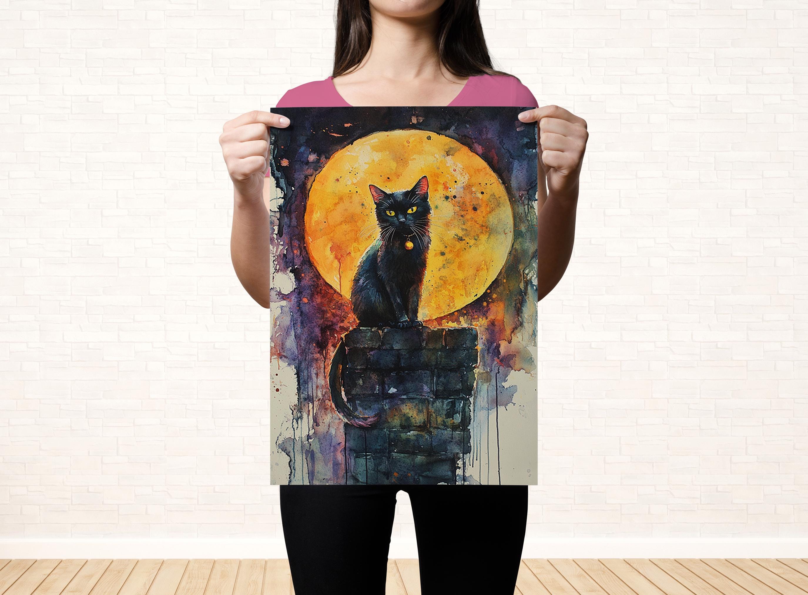 A woman is holding up a poster featuring a black cat sitting on a brick wall, with a large orange and yellow moon in the background.