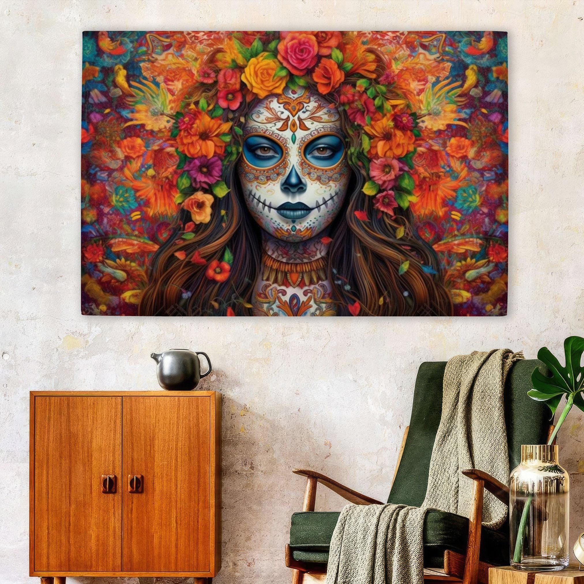 a large, colorful painting of a woman with a sugar skull design, surrounded by a vibrant floral arrangement. The painting is displayed on a wall above a wooden cabinet and a green armchair, creating a striking visual focal point in the room.