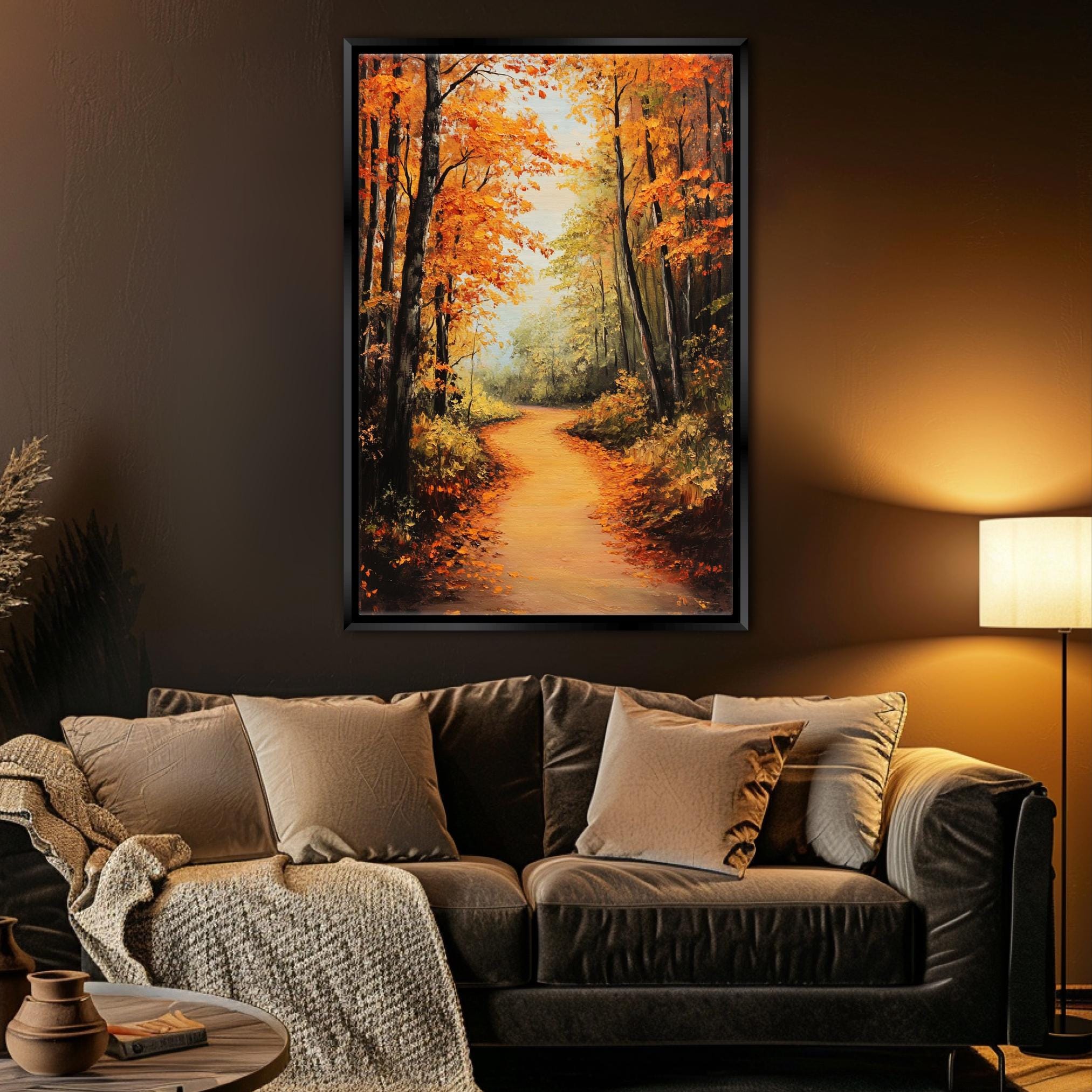 a cozy living room with a large painting of a forest path in autumn hanging on the wall above a brown leather couch.