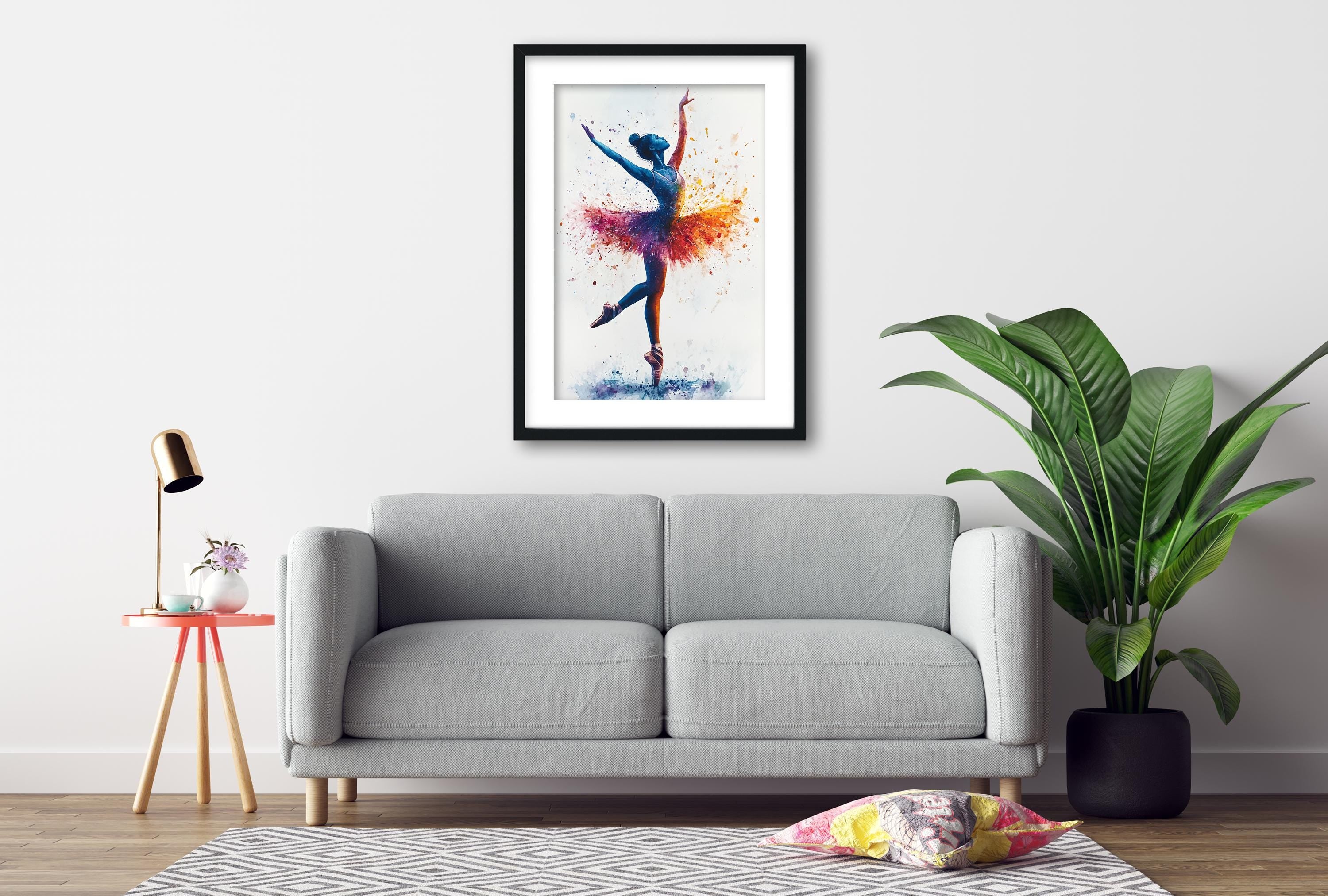 a gray sofa, a framed painting of a ballerina, a small table with a lamp, and a potted plant, all arranged in a living room setting.