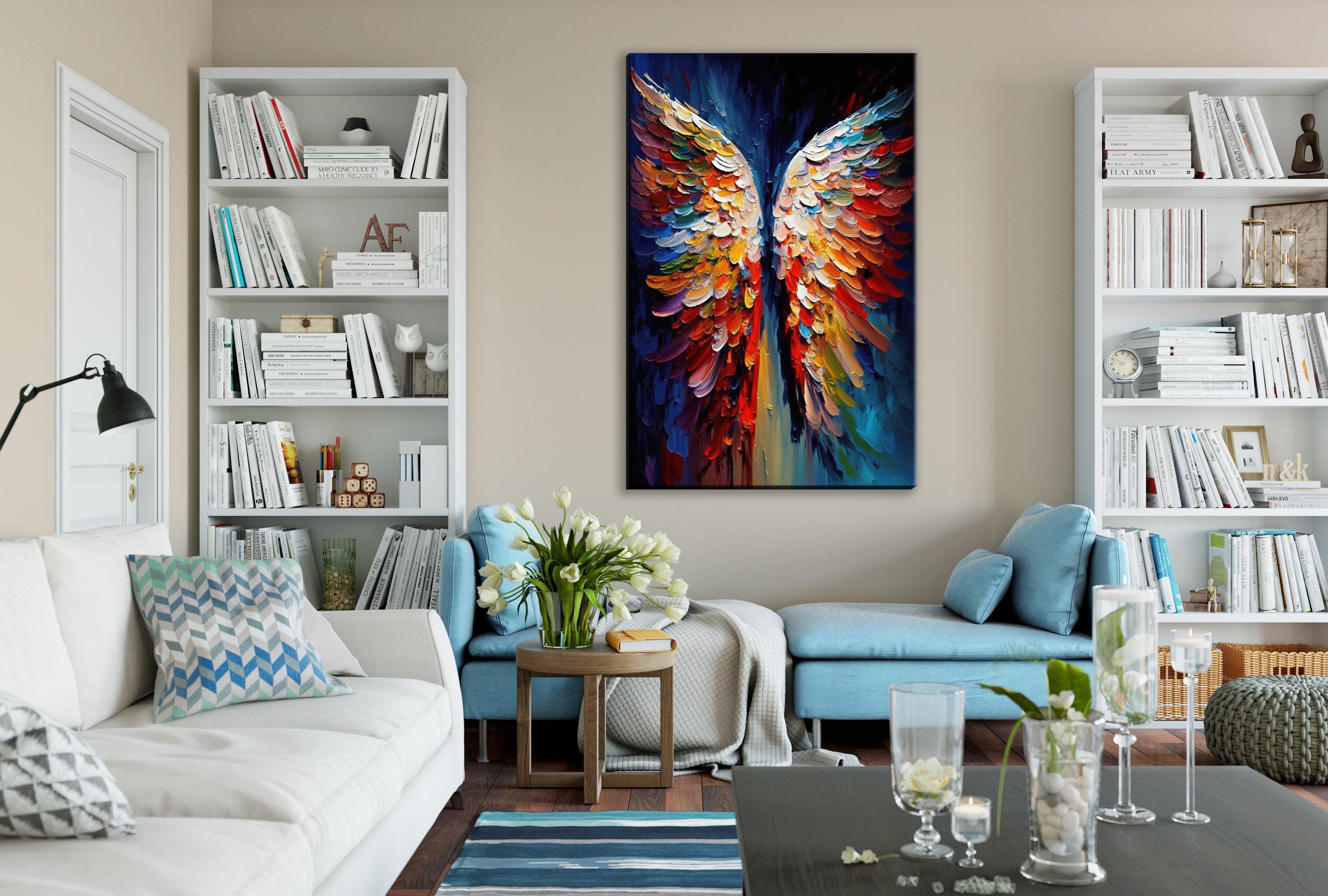 a cozy living room with a large, colorful painting of wings hanging on the wall. The room is furnished with a white sofa, a blue armchair, and a wooden coffee table. The walls are lined with bookshelves filled with books, and there are vases and candles adding to the room's decor.