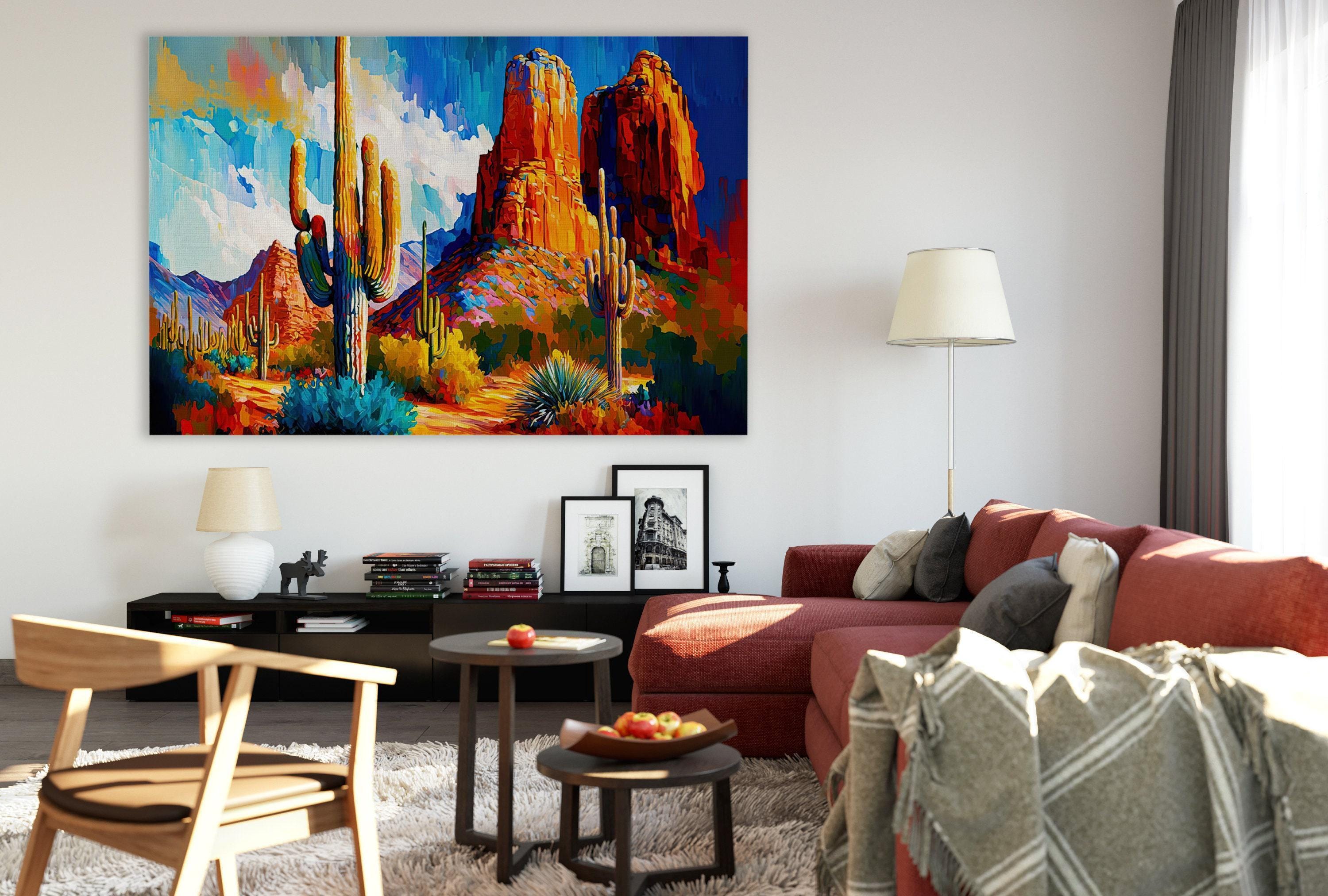 a modern living room with a large, colorful painting of a desert landscape hanging on the wall. The room is furnished with a red sofa, a wooden chair, and a coffee table with a bowl of fruit. The overall decor has a contemporary and stylish feel.