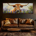 a large painting of a bull with long horns, surrounded by a field of purple flowers, hanging on a wall above a brown leather couch in a living room setting.