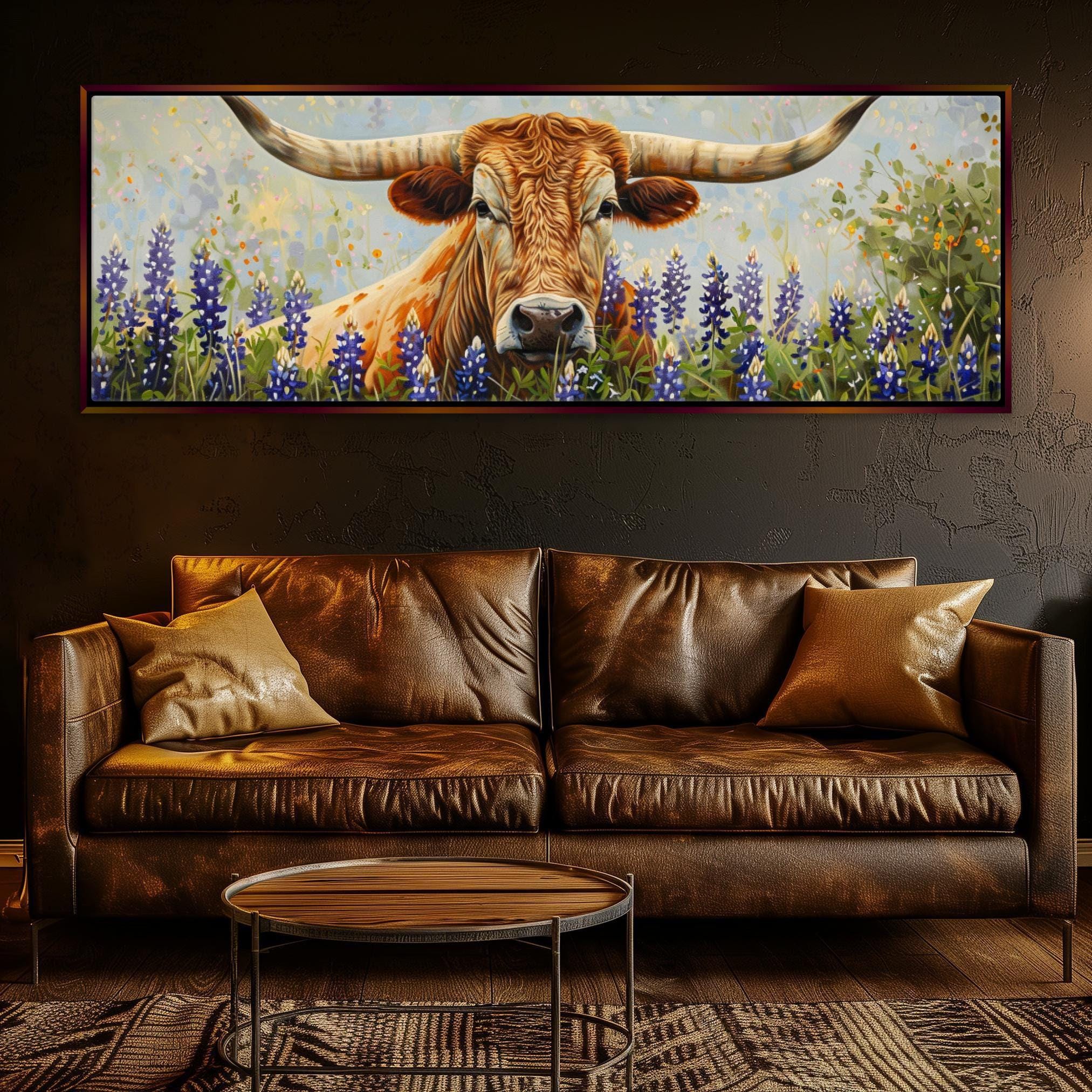 a large painting of a bull with long horns, surrounded by a field of purple flowers, hanging on a wall above a brown leather couch in a living room setting.