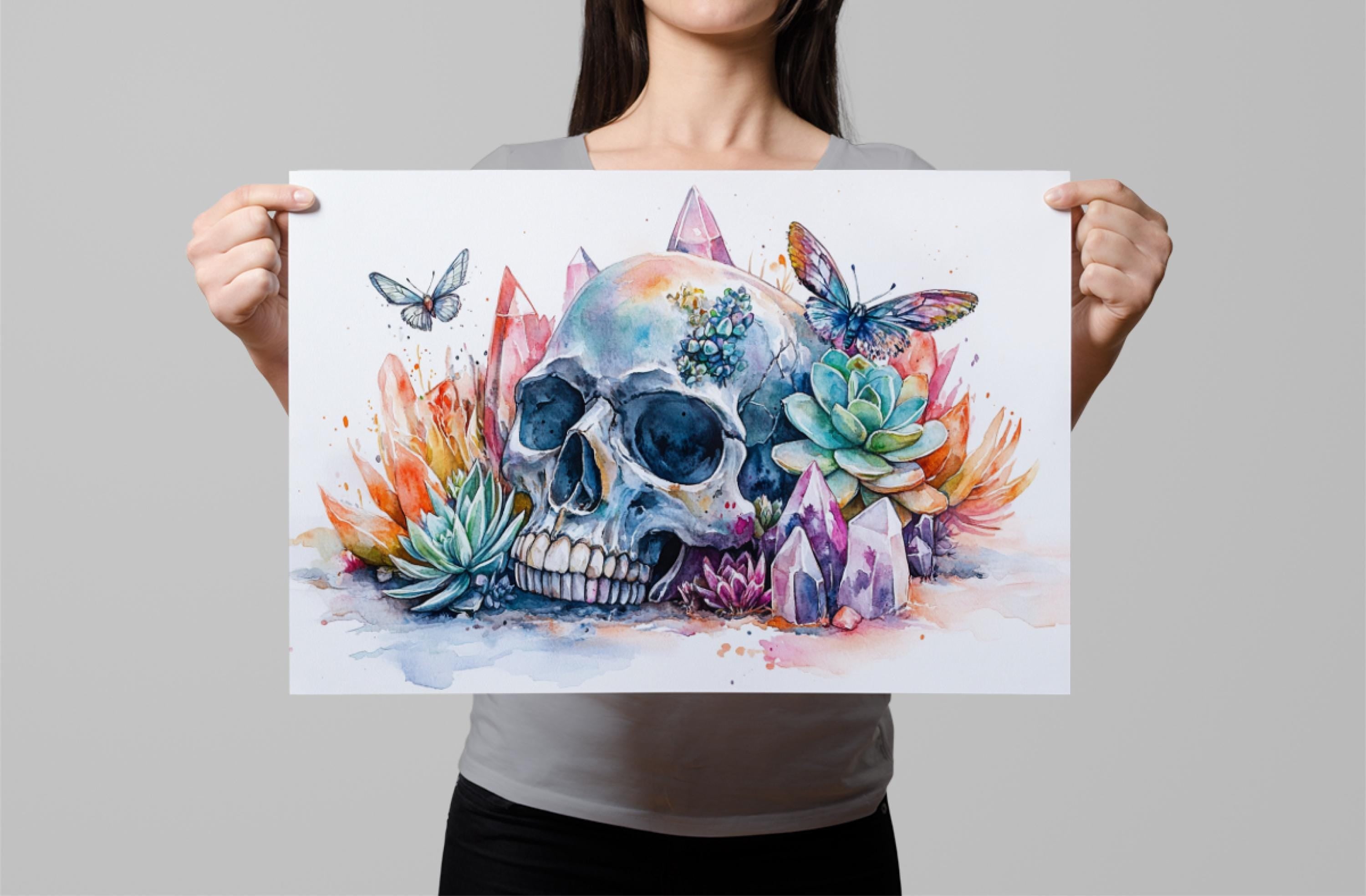 A woman holds up a colorful and vibrant painting depicting a skull surrounded by various flora and fauna, including butterflies and crystals.
