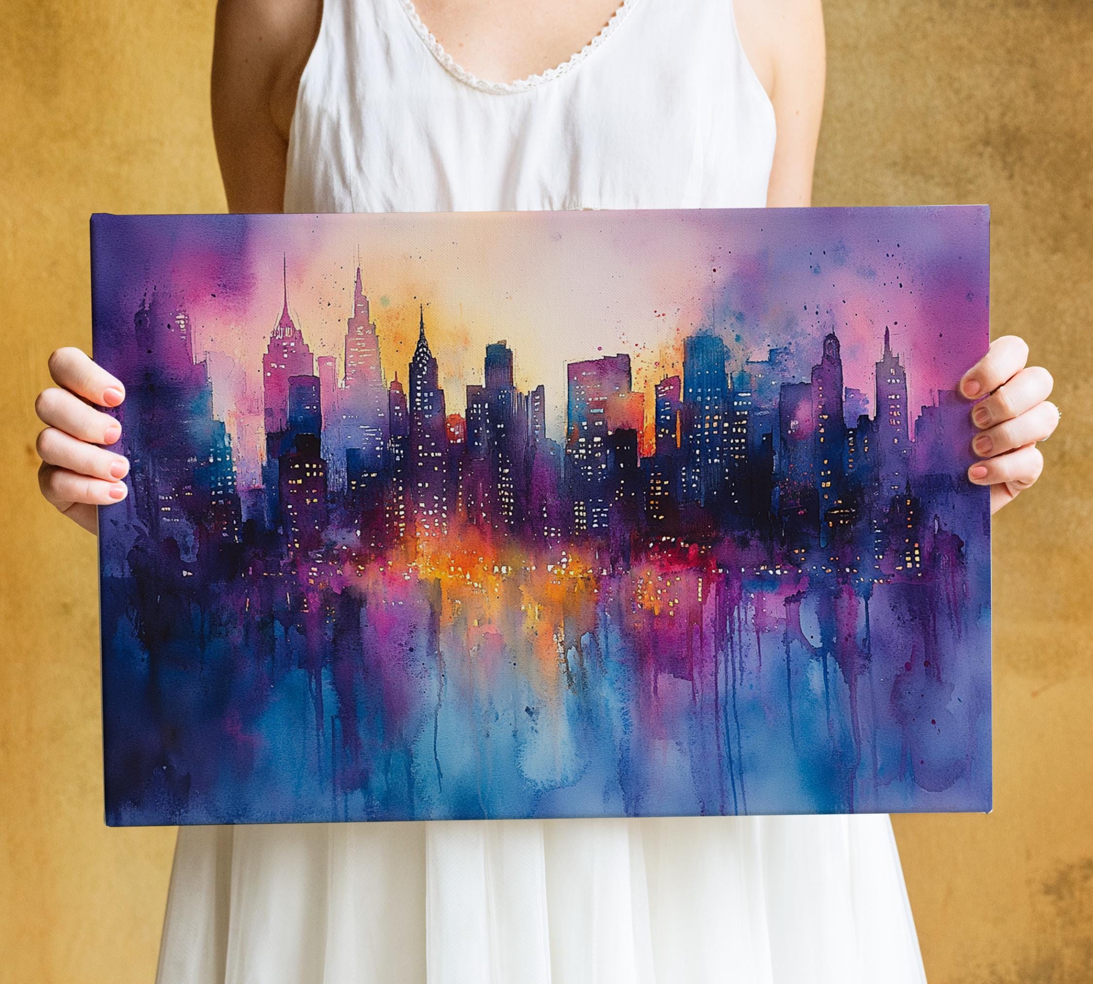 A person is holding a large painting of a cityscape with a colorful, abstract design featuring buildings and city lights.
