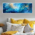 a bed with yellow pillows and a large painting on the wall
