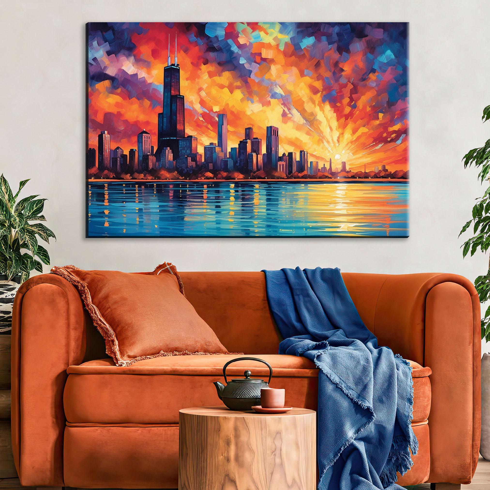 a large, colorful painting of a city skyline with a sunset over the water, hanging on a wall above a cozy living room setting with a brown sofa and a wooden side table.