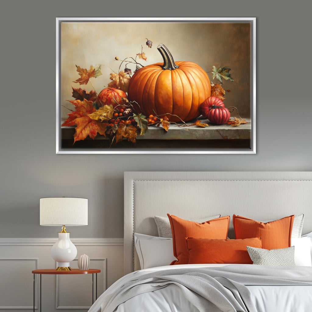 a large framed painting of a pumpkin and autumn leaves on a wall above a bed with orange pillows and a white headboard.