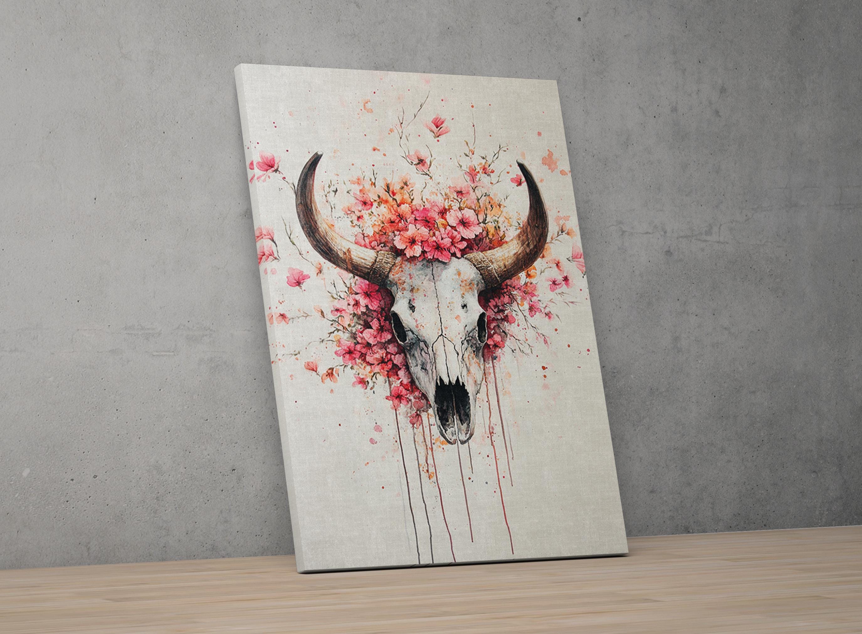 a skull with large horns, surrounded by a floral arrangement of pink flowers.