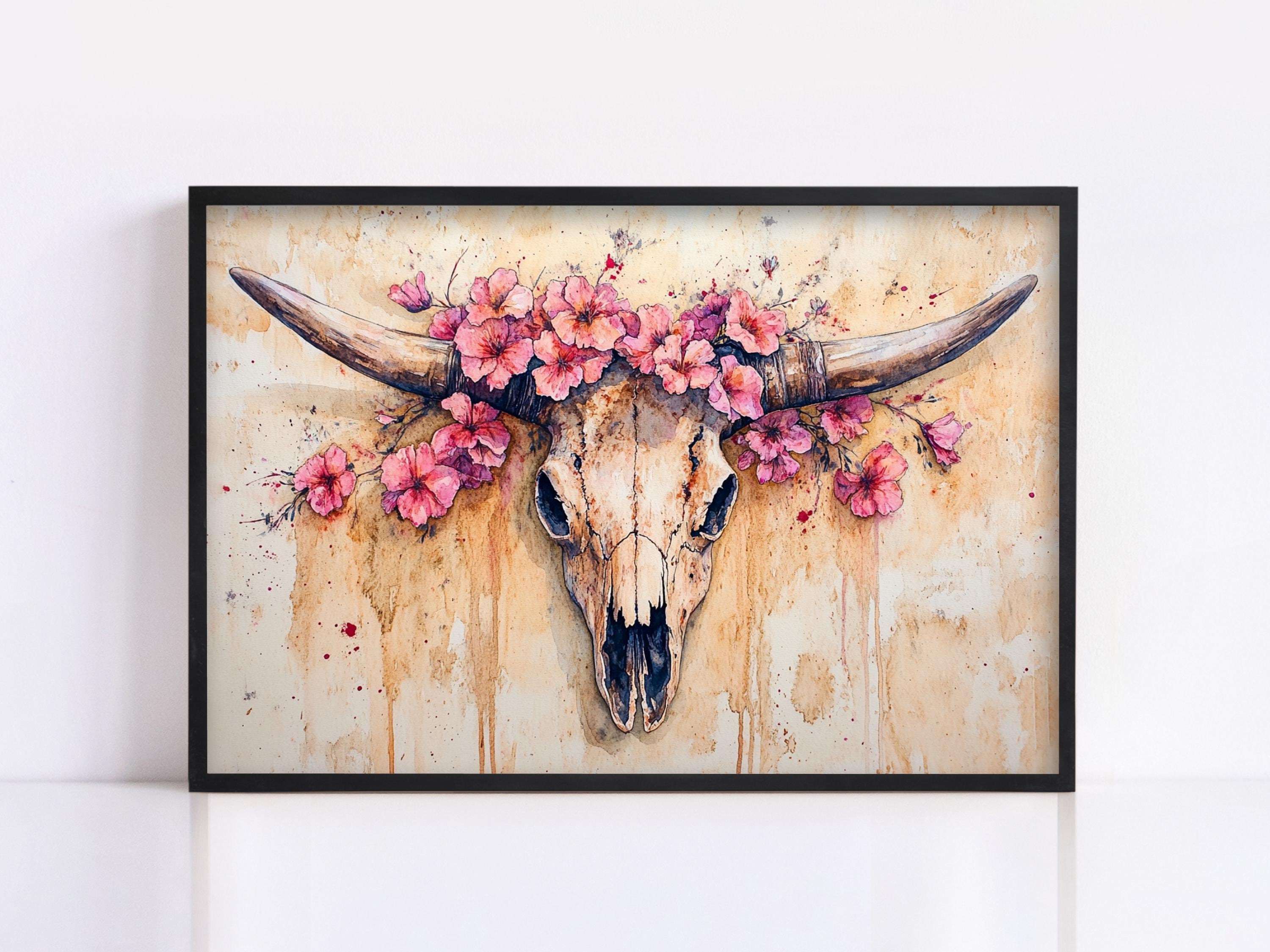 A framed painting depicting a skull with large horns adorned with pink flowers.