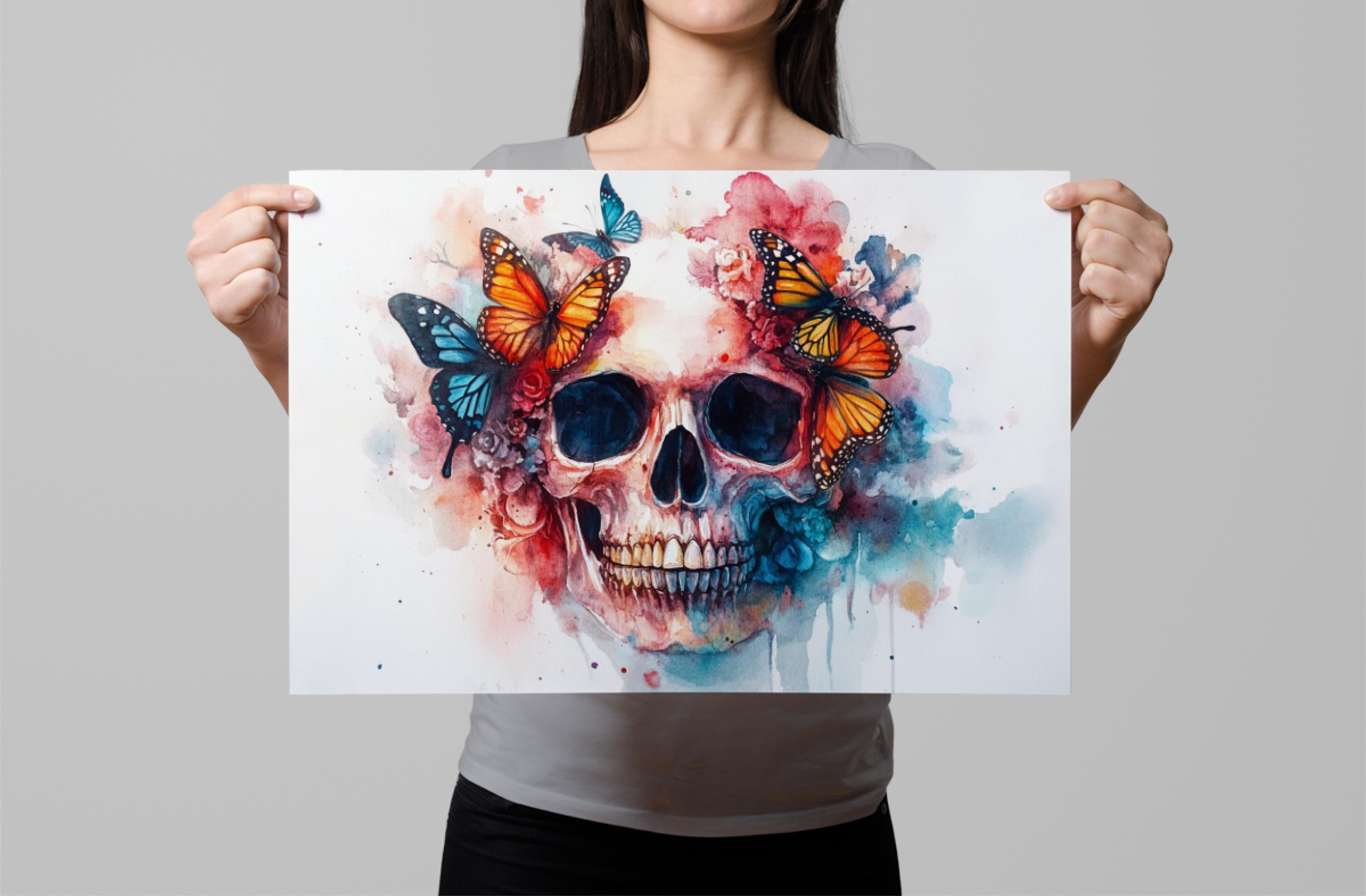 A woman holds up a colorful painting of a skull with butterflies and flowers.