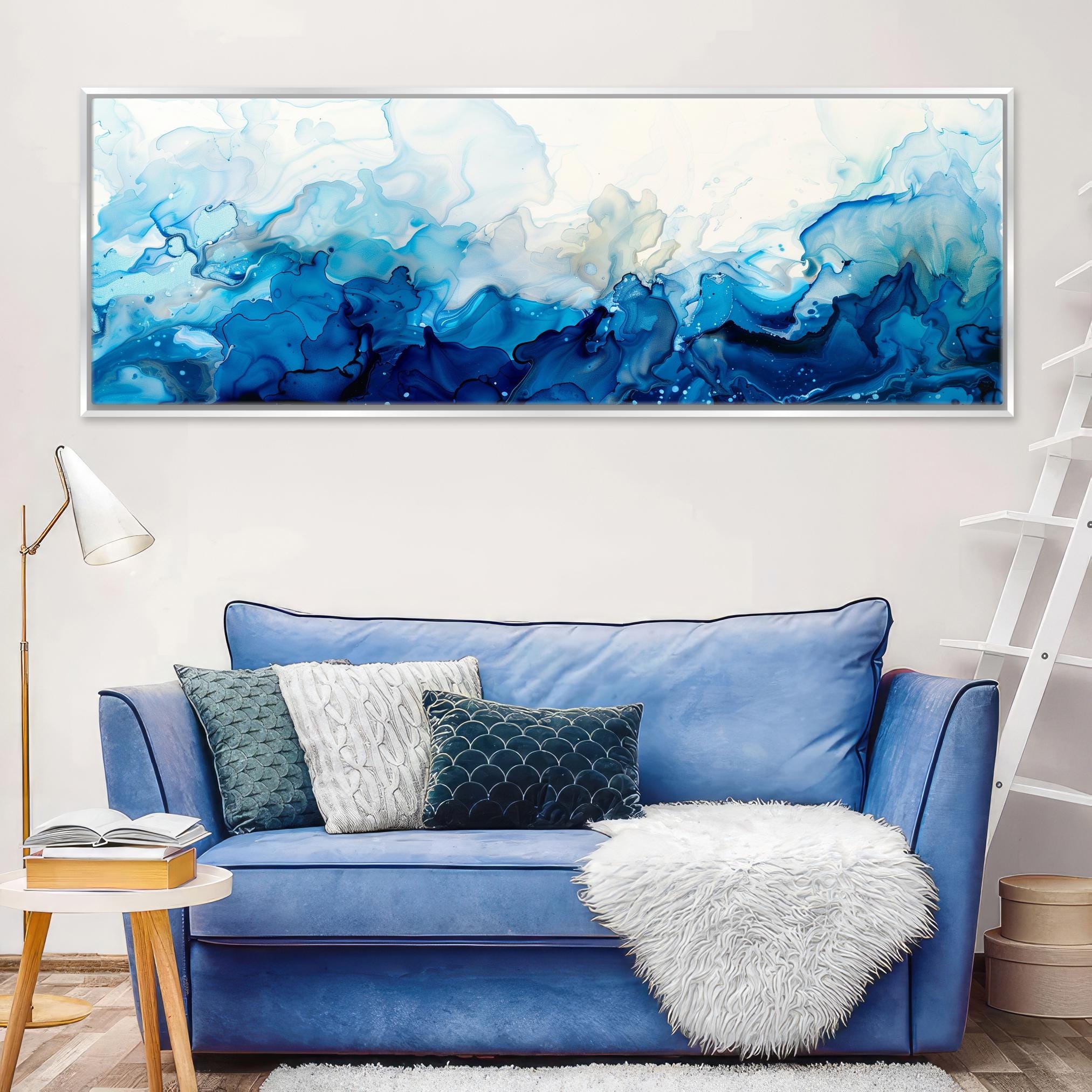 a living room with a blue couch and a painting on the wall
