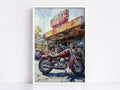 A red motorcycle is parked in front of a dilapidated gas station with a faded sign.