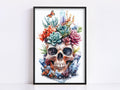 The image is a framed artwork depicting a skull surrounded by a variety of colorful flowers, plants, and crystals.