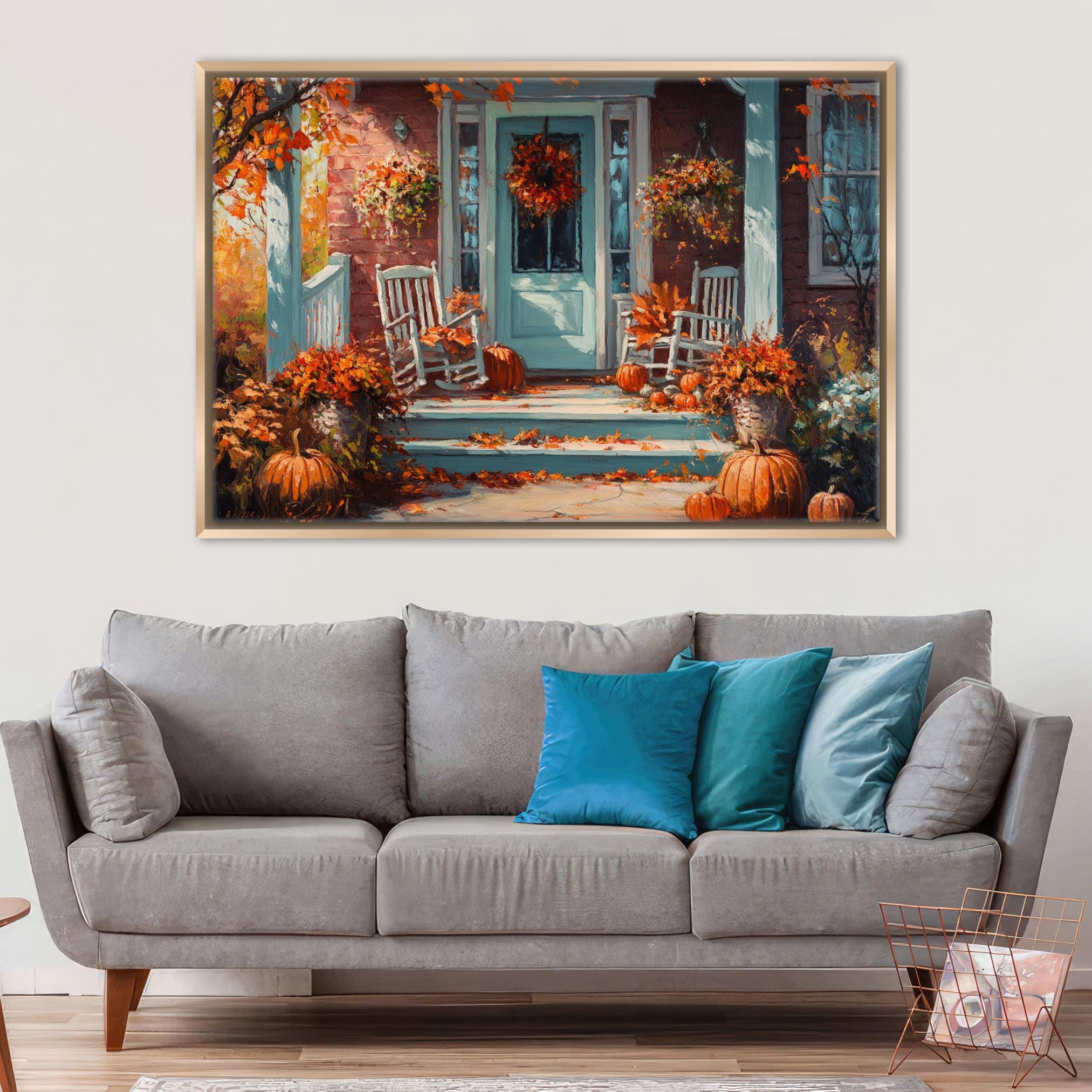 a cozy living room with a gray sofa adorned with blue throw pillows, and a large framed painting of a porch with autumn decorations hanging above it.