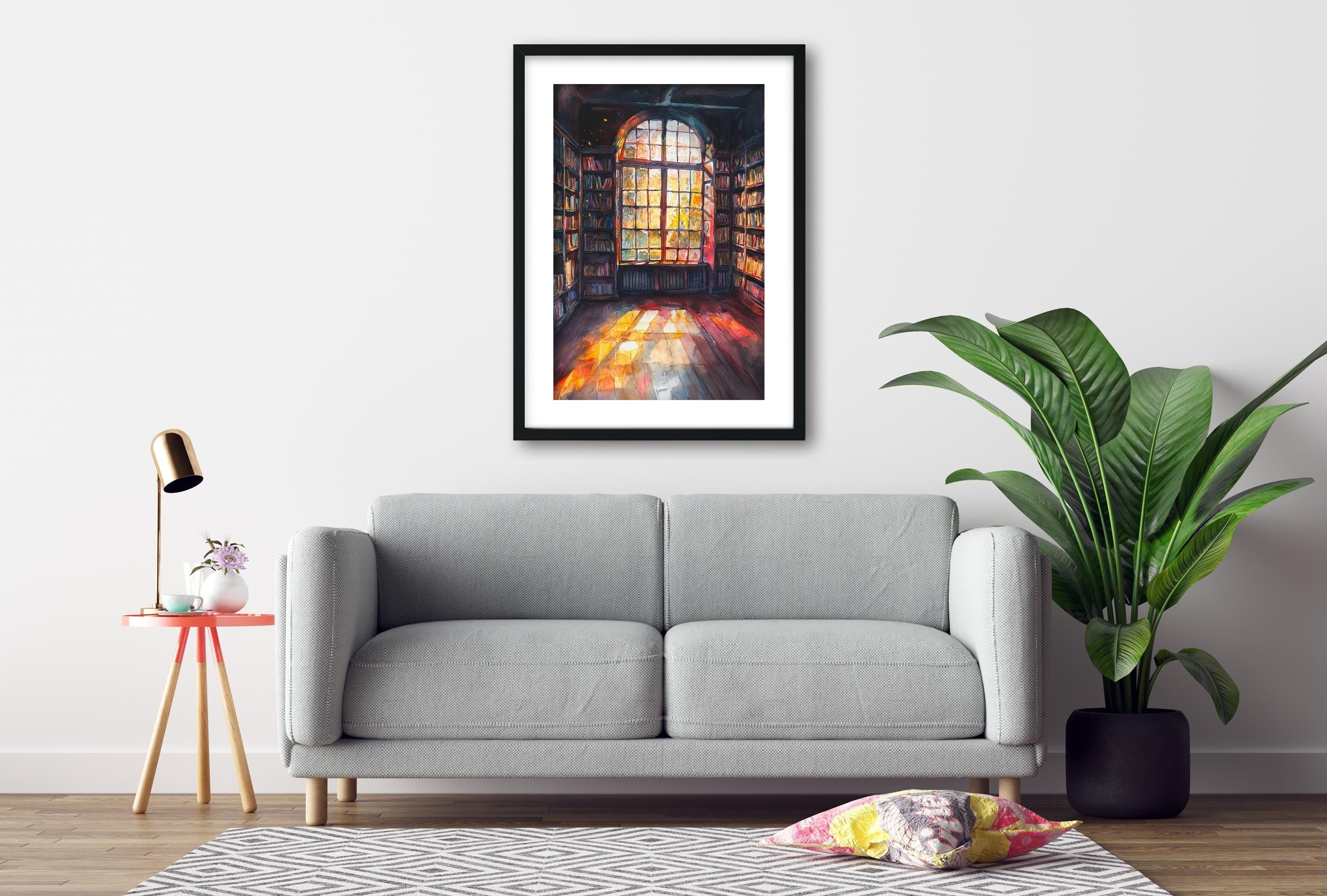 a cozy living room with a gray sofa, a framed painting of a colorful stained glass window, a small table with a lamp, and a potted plant.