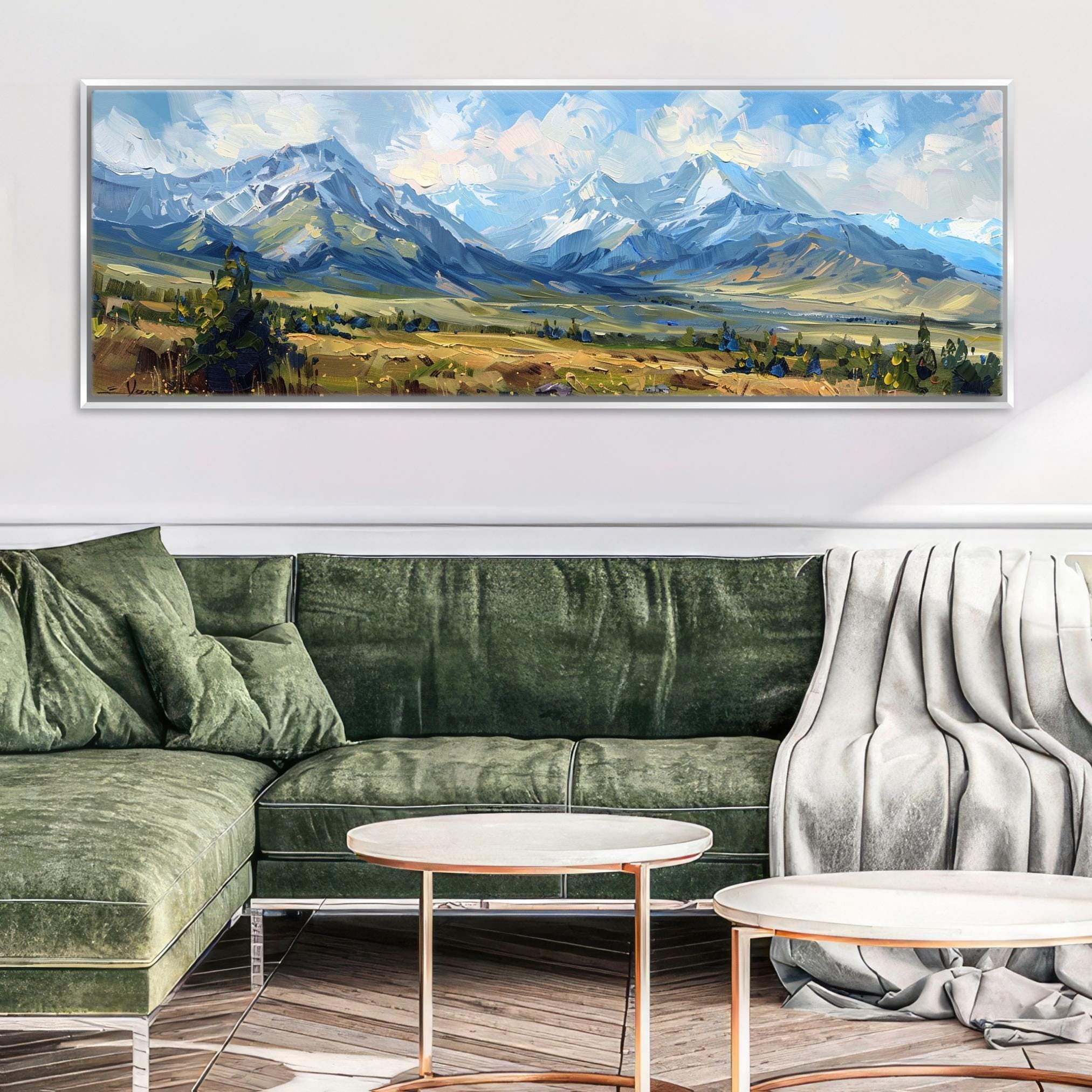 a large landscape painting hanging on a wall above a green sofa in a living room setting.