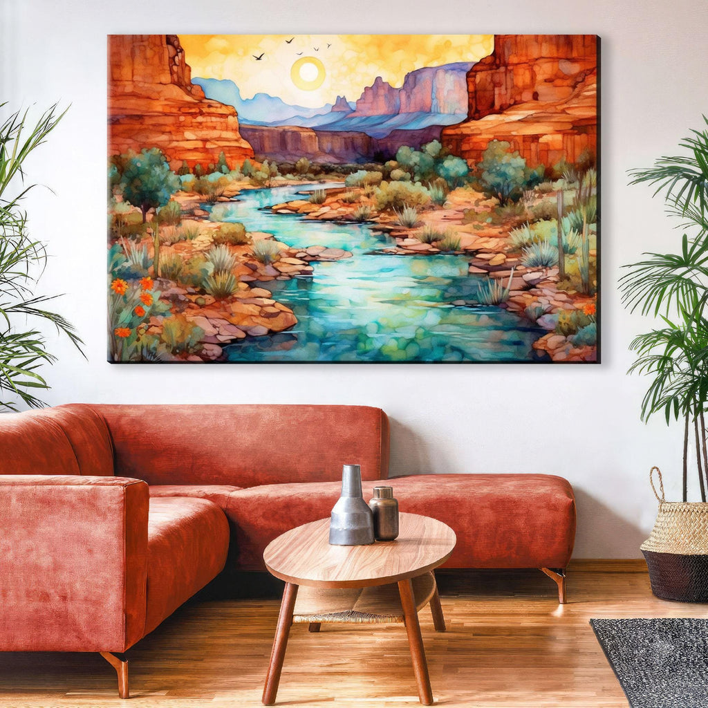 a large, colorful painting of a desert landscape with a river, mountains, and a sun in the sky. The painting is hung on a wall above a red couch and a coffee table in a living room setting.