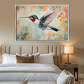 a painting of a hummingbird on a wall above a bed