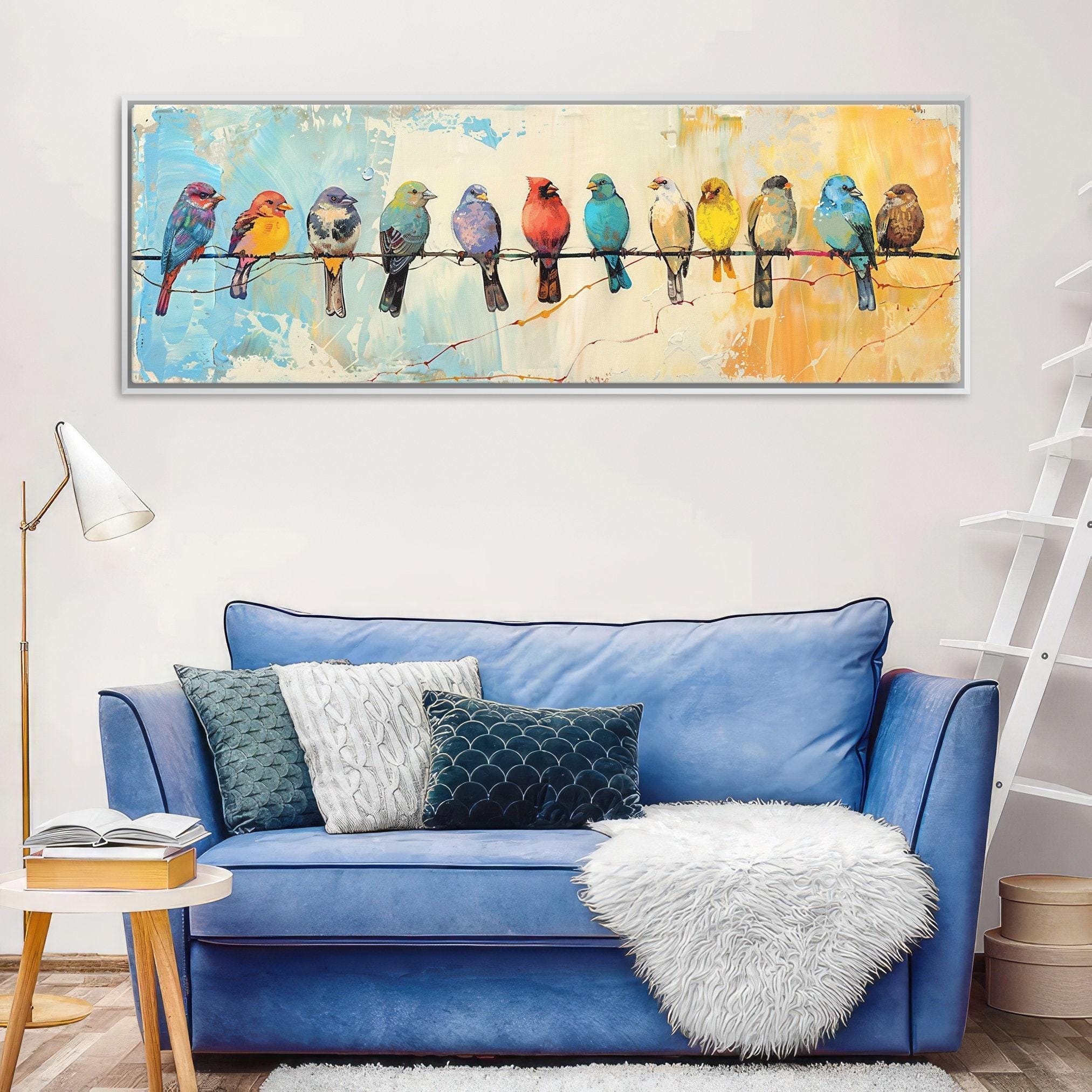 a blue couch with white throw pillows, a white shag rug, and a white fur throw. Above the couch, there is a large painting of colorful birds perched on a wire.