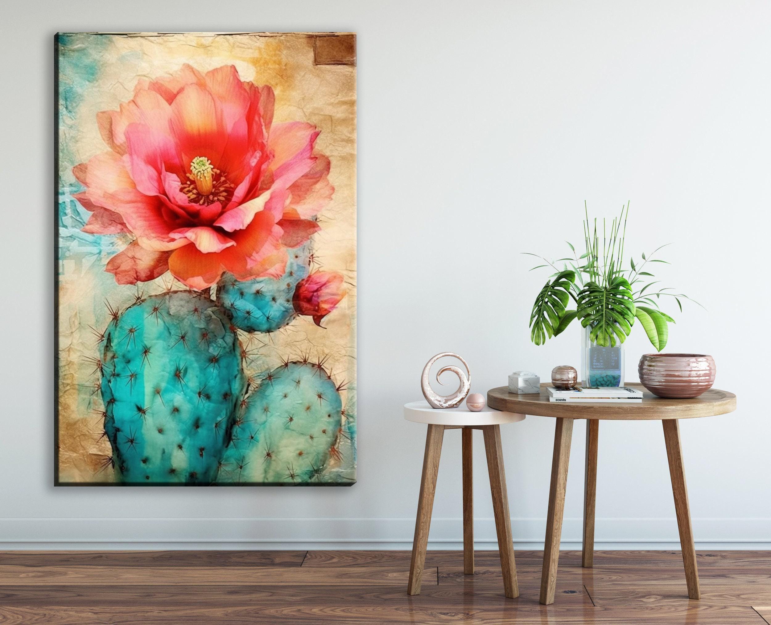 a large, vibrant painting of a cactus with a large, red flower on its side, hanging on a wall next to a small round table with a plant and other decorative items.