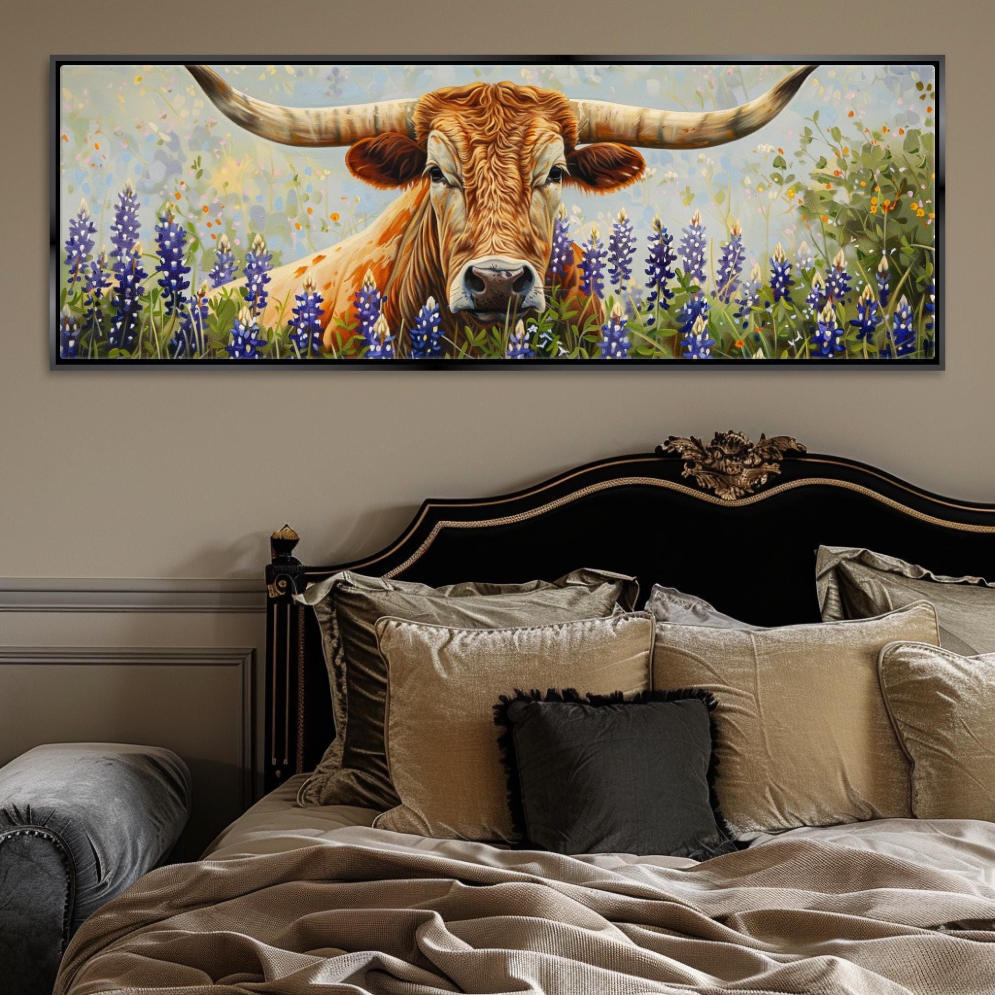 a large painting of a bull with long horns, surrounded by a field of blue flowers, hanging above a bed with a black headboard and beige bedding.