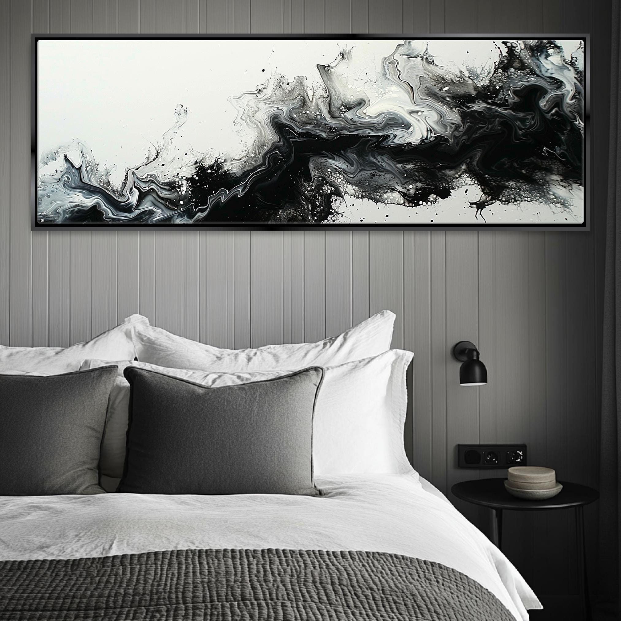 a black and white painting hanging above a bed