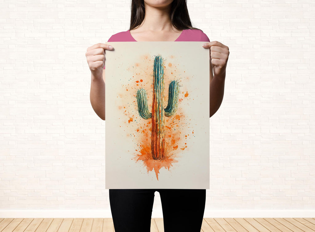 A woman is holding up a framed print of a cactus with a watercolor effect, featuring a vibrant mix of orange and green colors.