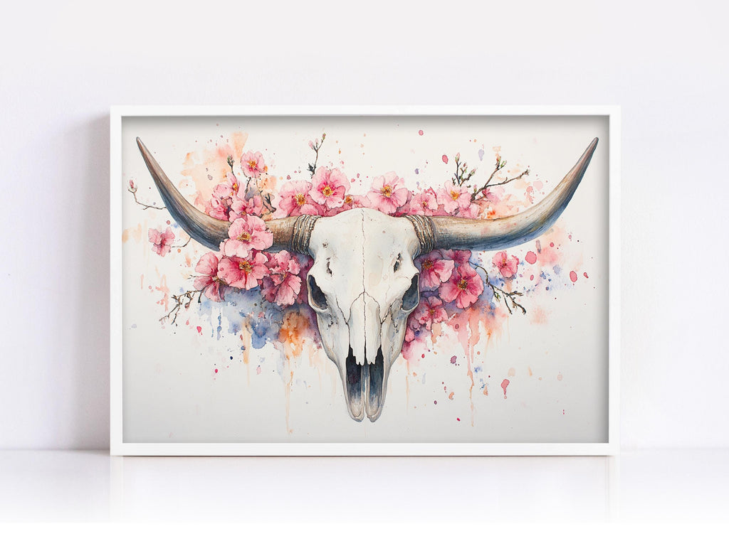 A framed painting depicting a white skull with large horns, surrounded by pink flowers and splashes of color.