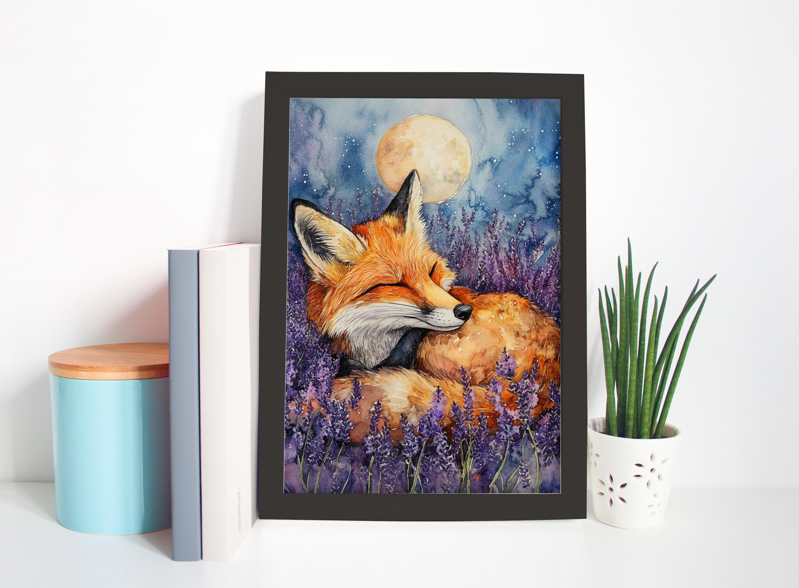 A framed painting of a sleeping fox is displayed on a shelf, surrounded by a blue container, a white pot with a plant, and a stack of books.